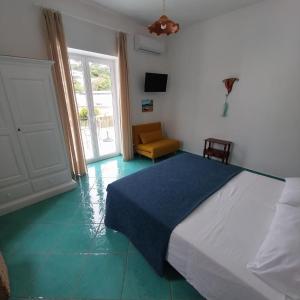 a bedroom with a bed and a chair and a window at Villa del Sole in Capri