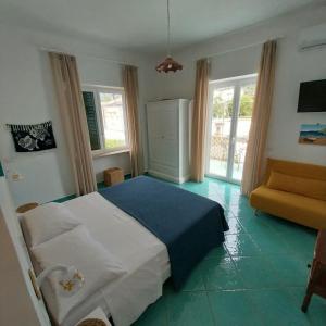 a bedroom with a bed and a couch and windows at Villa del Sole in Capri
