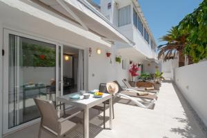 a patio with a table and chairs on a balcony at Sabbia Suites Noa Boutique Apartments in Puerto del Carmen