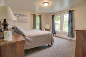 a bedroom with a bed and a desk and windows at Family Home and Private Hot Tub on Susquehanna River in Wrightsville