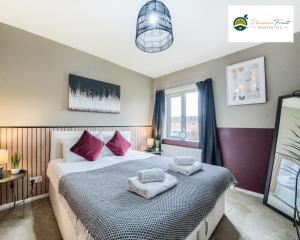 um quarto com uma cama com almofadas cor-de-rosa e uma janela em 3 BedRoom House with 5 Beds House By Passionfruit Properties Near Coventry City Centre - BCC em Coventry