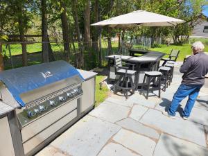 a man standing in front of a barbecue grill at Captain Dan's Shanty in Saint Andrews