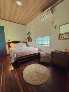 1 dormitorio con cama y alfombra en el suelo en Casa de Campo Riachuelo Verde, en Aguas Zarcas