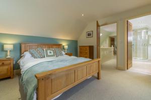 a bedroom with a large bed with a wooden frame at Kittiwake Cottage in Brancaster
