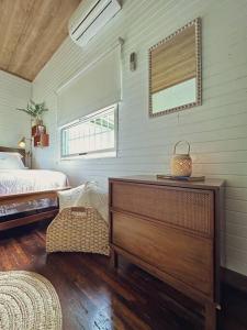 a bedroom with a bed and a dresser in a room at Casa de Campo Riachuelo Verde in Aguas Zarcas