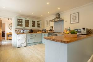 a kitchen with blue cabinets and a counter top at Hideaway House in Wells next the Sea