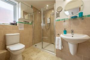 a bathroom with a toilet and a sink and a shower at Hideaway House in Wells next the Sea