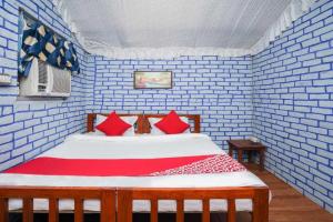 een blauwe kamer met een bed met rode kussens bij OYO Flagship RS Woods in Pushkar