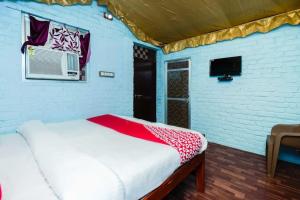 een kamer met een bed, een raam en een tv bij OYO Flagship RS Woods in Pushkar