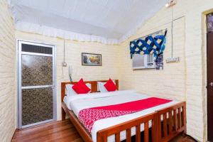een slaapkamer met een bed met rode kussens en een raam bij OYO Flagship RS Woods in Pushkar