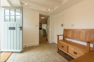 a hallway with a door leading to a bathroom at Old Posting in Brancaster +39 photos