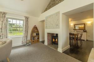 a living room with a fireplace and a table at Old Posting in Brancaster