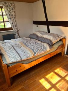 a bed with a wooden frame in a room at Fachwerk in Bergfreiheit in Bad Wildungen
