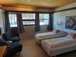 una camera d'albergo con due letti e una sedia di Øiseth Hotell AS a Rendalen