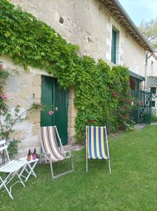 two lawn chairs sitting in the grass in front of a building at Le Relais des Roses- Chambres d'hôtes in Vatan