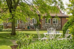 un tavolo e delle sedie davanti a una casa di Westgate Cottage T 4 a Thornham