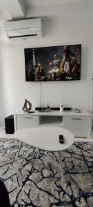 a white living room with a tv on a wall at Euphoria Neptun Oxygen in Neptun