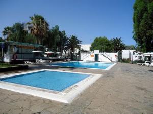a large swimming pool in a yard with trees at Cozy studio in Costa del Silencio in the south coast of Tenerife in Costa Del Silencio