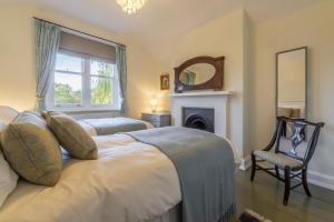 1 dormitorio con cama, espejo y silla en Coachmans Cottage, en New Hunstanton