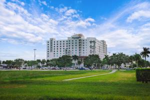- un grand bâtiment blanc avec un parc en face dans l'établissement Miccosukee Casino & Resort, à Miami