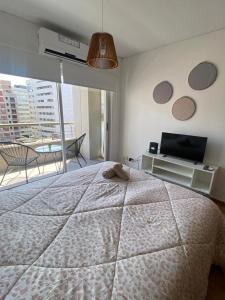 1 dormitorio con cama, TV y balcón en MYSOHO - Luminoso y comodo Studio - Villa Crespo - Palermo- Movistar Arena en Buenos Aires
