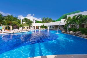 a swimming pool in front of a villa at Grand Oasis Tulum Riviera - All Inclusive in Akumal