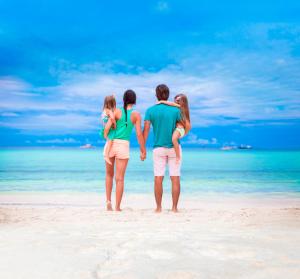 a group of three people standing on a beach at Grand Oasis Tulum Riviera - All Inclusive in Akumal