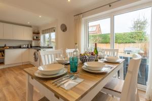 een keuken en eetkamer met een tafel en stoelen bij Cherry Tree Cottage GB in Great Bircham