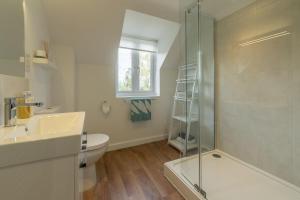 a bathroom with a shower and a toilet and a sink at Cherry Tree Cottage GB in Great Bircham +26 photos