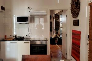 a kitchen with a stove and a tv on the wall at Amazing 2bedbath Apartment 1min To The Beach in Perth