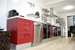 een grote keuken met rode kasten en apparaten bij Exceptional 2 Bed 2 Bath W Ocean Views! in Perth