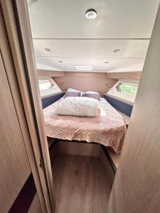 uma pequena cama no meio de um pequeno quarto em Puissance, Elegance et Style, Yacht à Deauville em Deauville