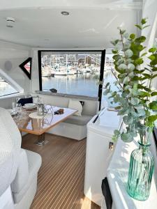 Puissance, Elegance et Style, Yacht à Deauville في دوفيل: قارب مع طاولة و إناء من الزهور