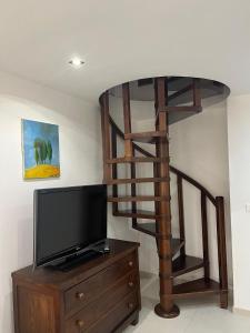 sala de estar con TV y escalera de caracol de madera. en Malvezzi 36, en Fano