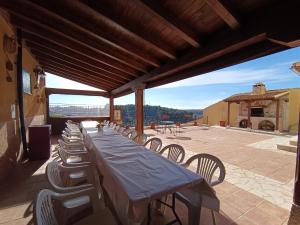 einen langen Tisch und Stühle auf einer Terrasse in der Unterkunft Casa de la Abuela Pili in Colmenar de Oreja