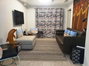 sala de estar con sofá y silla en Wonderful 2bed 2bath Apartment With Ocean Views ! en Perth