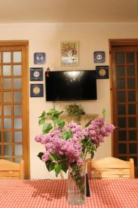 een vaas met paarse bloemen op een tafel bij Nitsa Guest House in Gori