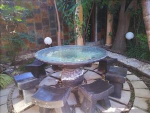 a stone table with benches around it in a garden at Sleep Haven in Johannesburg