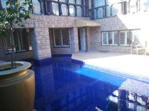 a house with a swimming pool in front of a building at Sleep Haven in Johannesburg