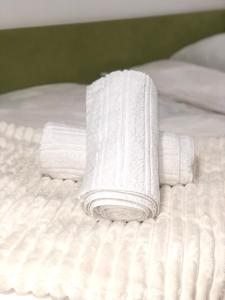 una pila de toallas blancas en una cama en Apartman Tadija Niš, en Donja Vrežina