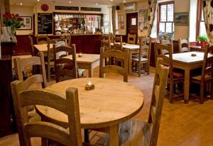 a restaurant with wooden tables and chairs and a bar at New Dungeon Ghyll Hotel in Great Langdale