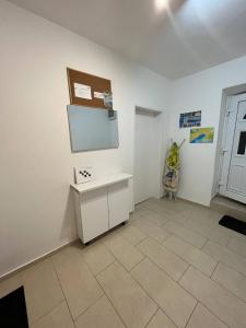 a white room with a table and a screen on the wall at Apartmani Luciano in Novalja