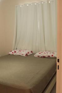 a bed with two pillows on top of it at Casa c WiFi e otima localizacao em Barreirinhas MA in Barreirinhas