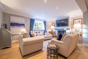 a living room with two couches and a tv at The Malthouse in Dersingham