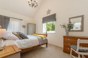 1 dormitorio con cama, escritorio y ventana en South Barn, en Stalham