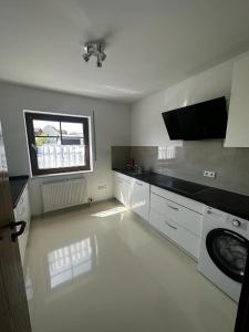 eine weiße Küche mit einer Waschmaschine in einem Zimmer in der Unterkunft Ferienwohnung Pfungstadt in Pfungstadt