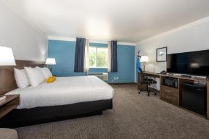 a hotel room with a bed and a flat screen tv at Hotel Pommier Indianola in Indianola