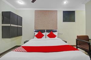 um quarto com uma cama grande e almofadas vermelhas em Super OYO Flagship Hotel Kanak International em Hyderabad