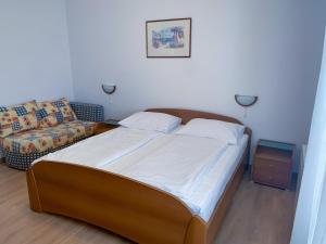 ein Schlafzimmer mit einem großen Bett und einem Sofa in der Unterkunft Haus Lupić in Rab