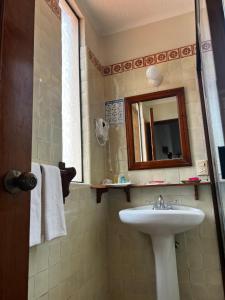 y baño con lavabo y espejo. en Casa Bugambilia, Un Pequeño Hotel en Tepoztlán, en Tepoztlán